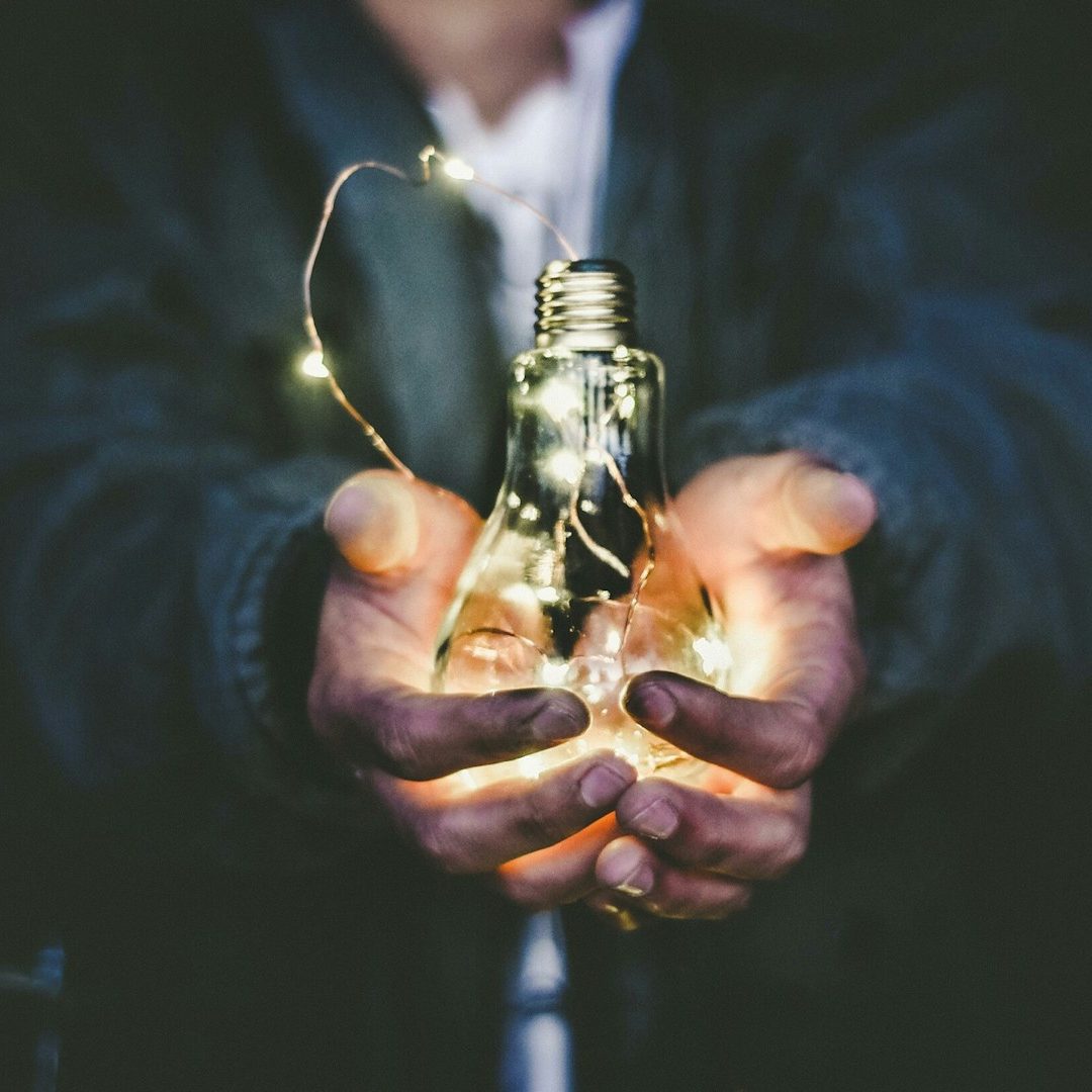 Eine Glühlampe wird in der Hand gehalten. Eine Glühlampe wird in der Hand gehalten.